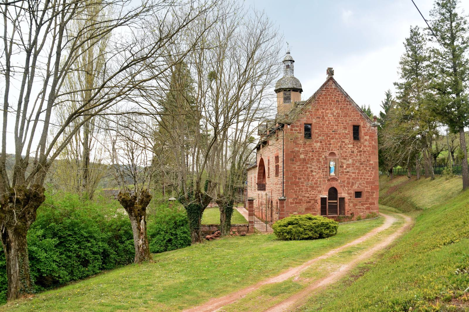La chapelle Notre-Dame de Foncourrieu en grès rouge et son clocheton, à Marcillac-Vallon en Aveyron