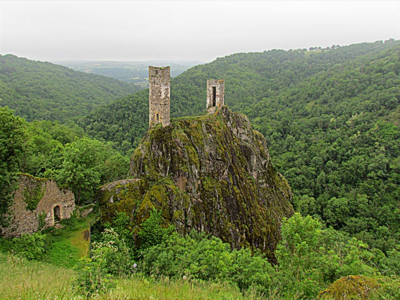 Les deux tours en ruine du château inférieur de Peyrusse-le-Roc, perchées sur un éperon rocheux au-dessus de la vallée, en Aveyron